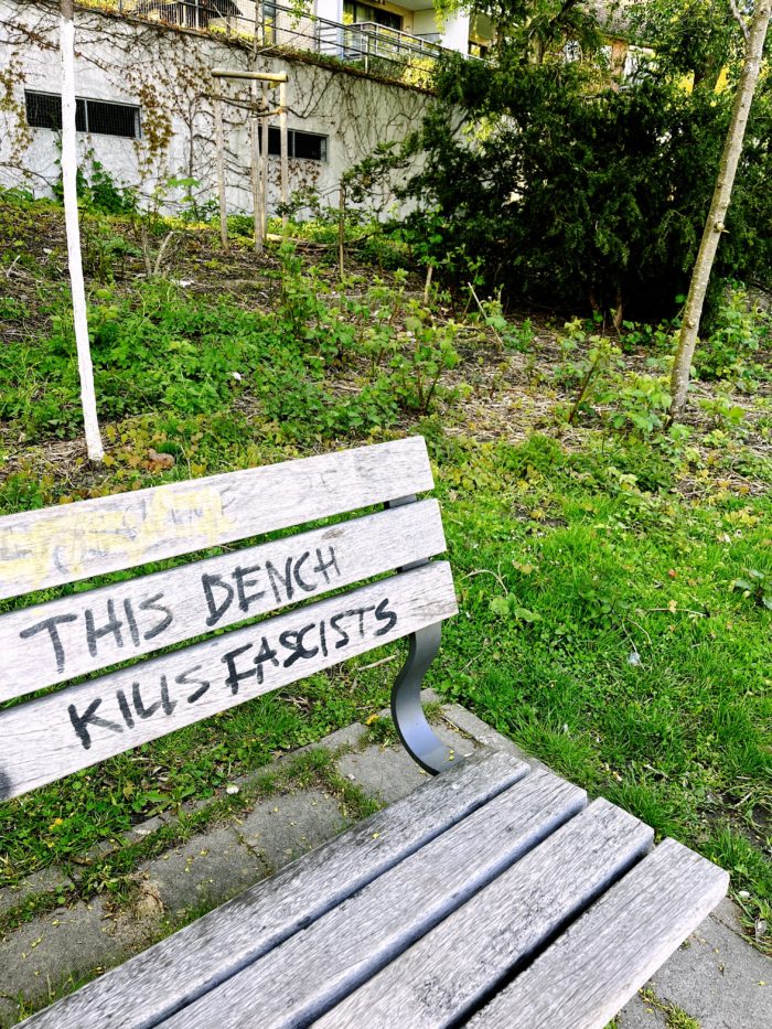 Eine Parkbank mit der Aufschrift "This bench kills fascists"