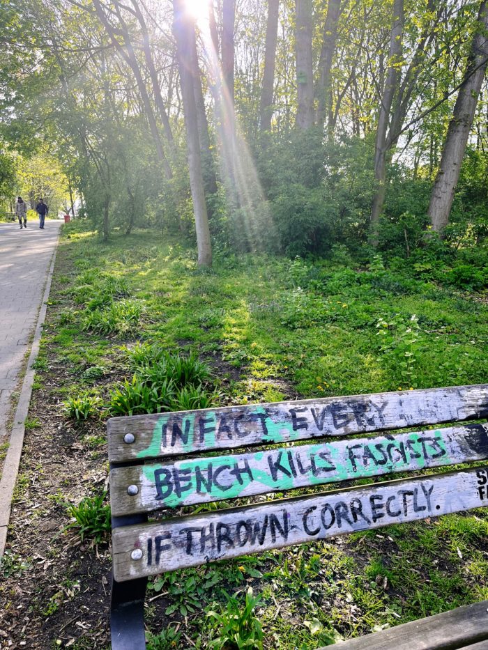 Eine Parkbank mit der Aufschrift "In fact every bench kills fascists if thrown correctly"