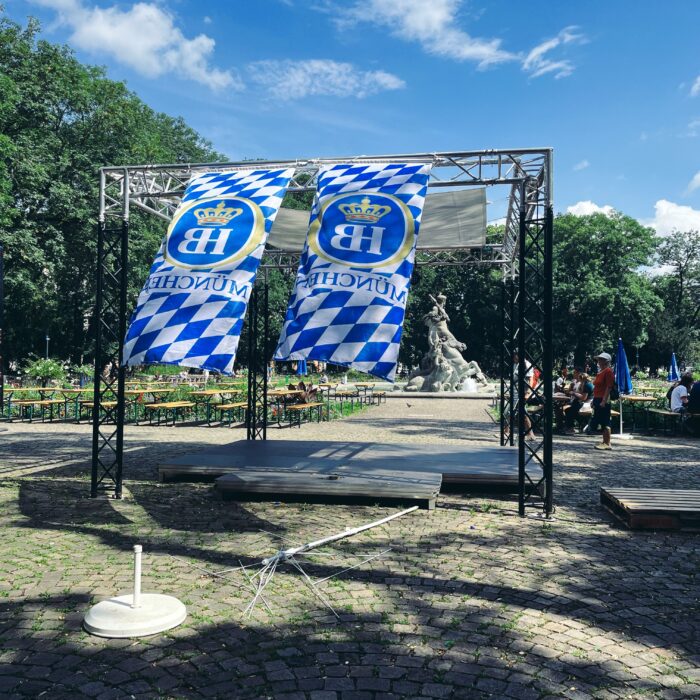 Zwei blauweiße Werbefahnen des Hofbräuhauses in München in einem Park