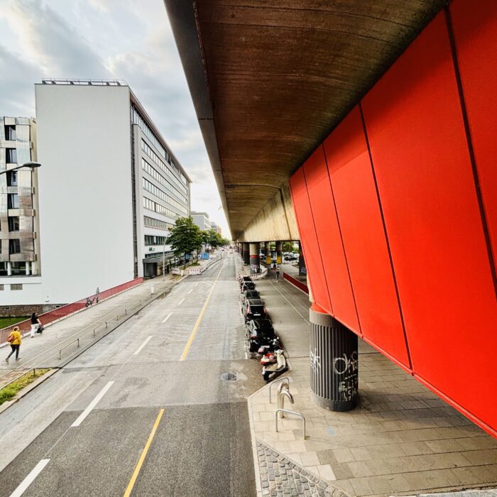 Die rote Außenwand der Haltestelle Hammerbrook, die Hammerbookstraße, ein hohes Bürogebäude