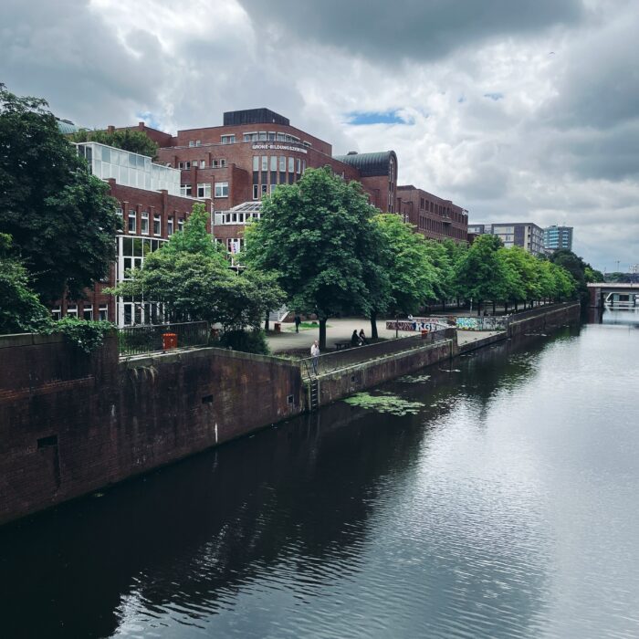 Das bebaute Ufer des Mittelkanals in Hammerbrook, grüne Bäume vor Bürohäusern