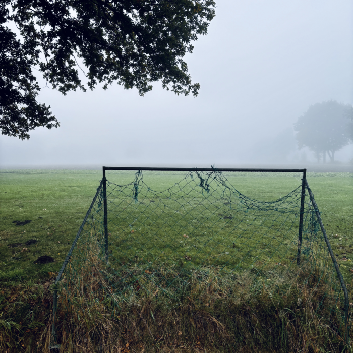 Ein Fußballtor mit zerrissenem Netz an einem Feldrand