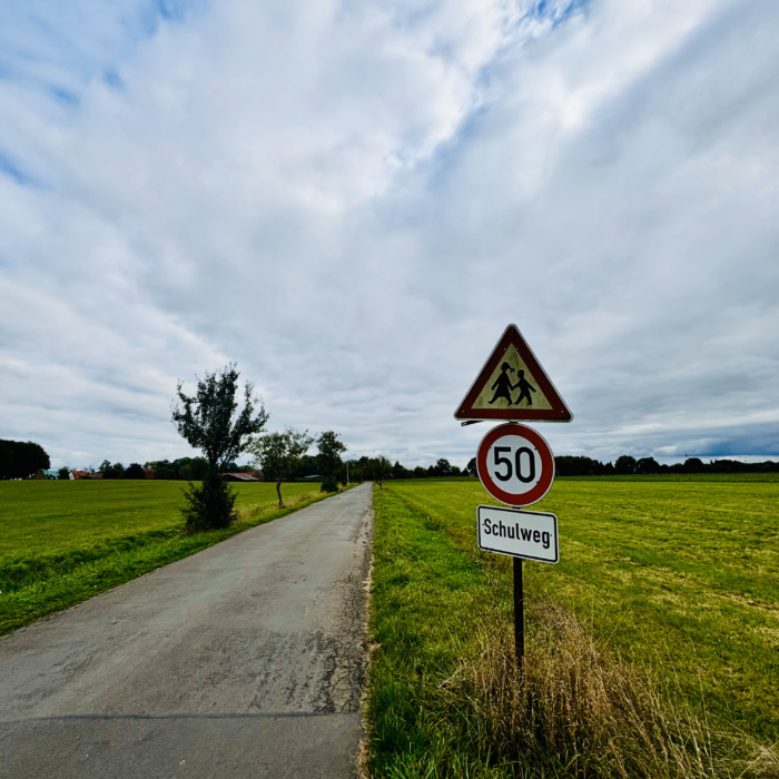 Ein Schulwegschild an einer menschenleeren Landstraße