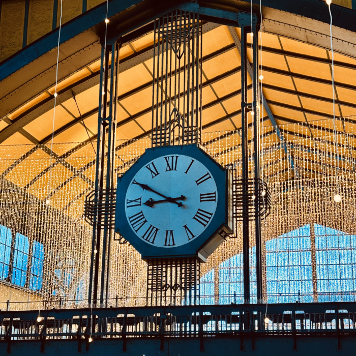 Die große Uhr in der Wandelhalle des Hamburger Hasuptbahnhofs vor Weihnachtsbeleuchtung