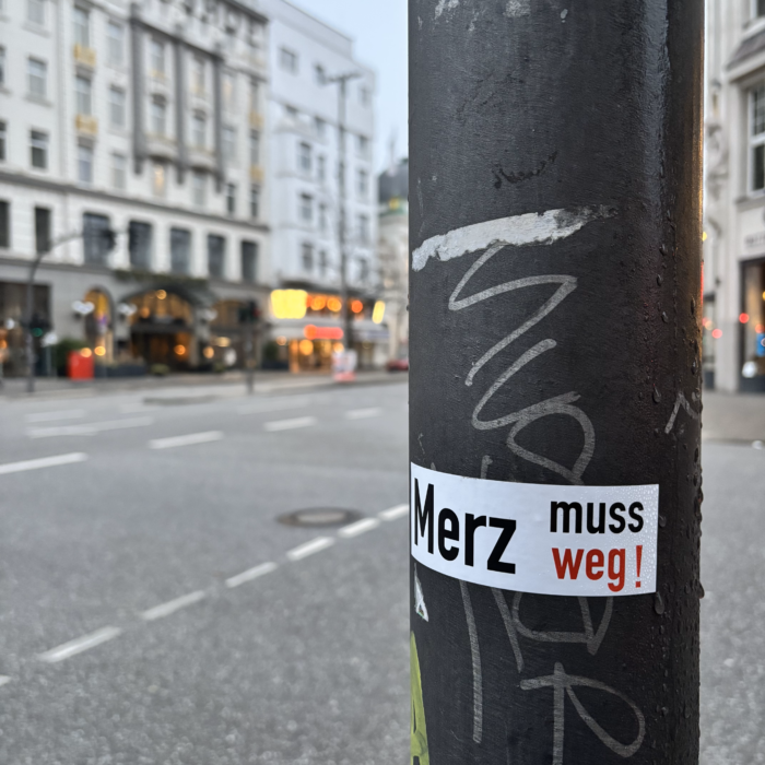 Ein Aufklkeber an einem Ampelmast: Merz muss weg.